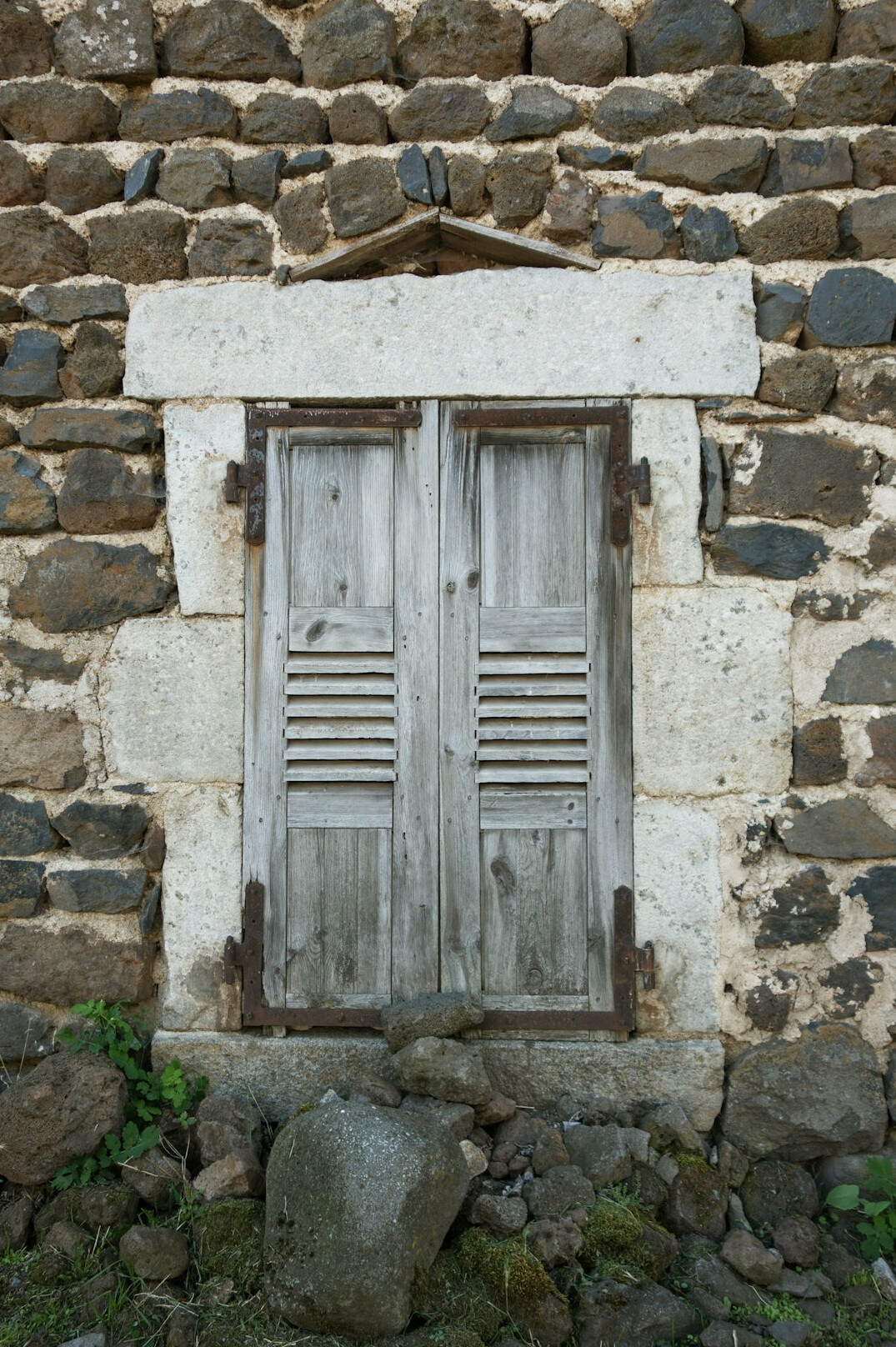 Colonial era stone building facade with old wooden shutters