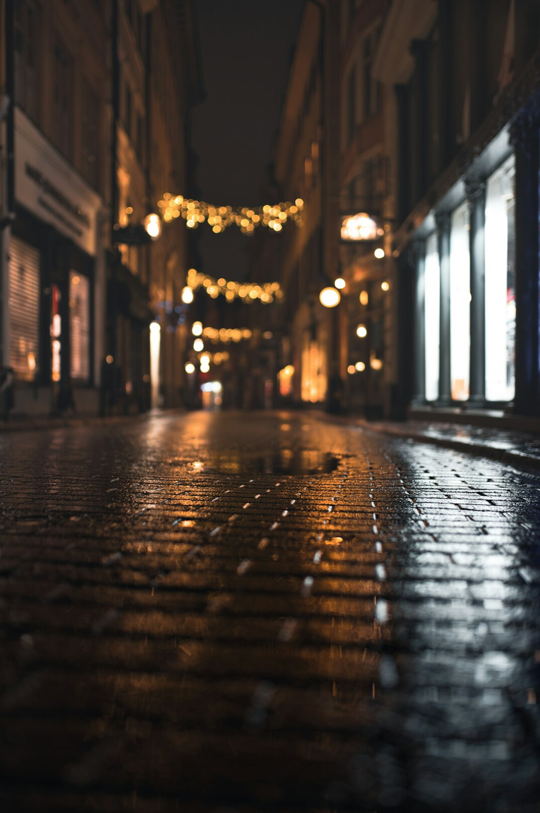 Empty rainy city street reflecting streetlights at night